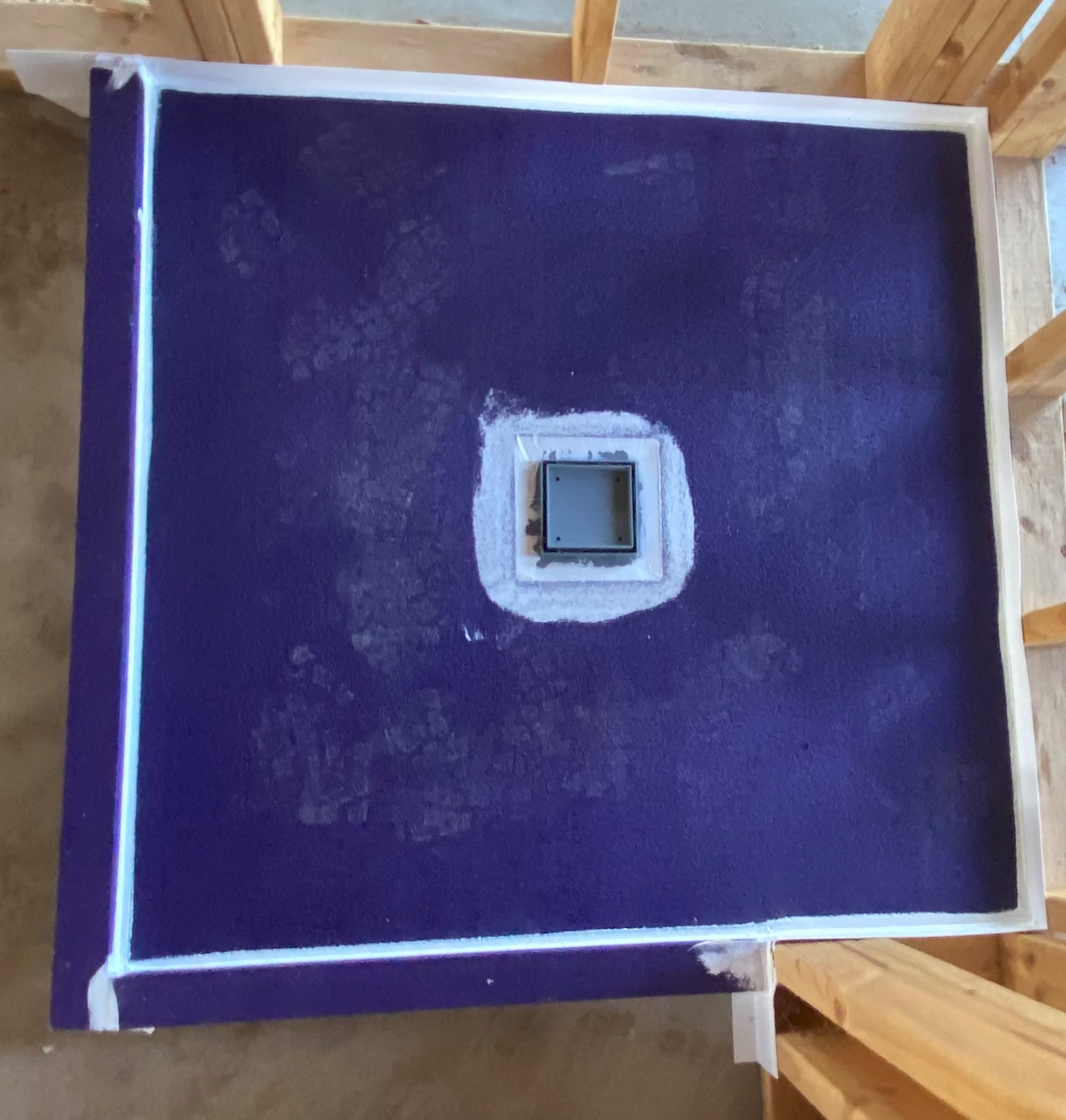 Overhead view of shower base with purple waterproofing membrane fully applied and waste fitting installed — Clyde North new build by Casey Quality Coatings