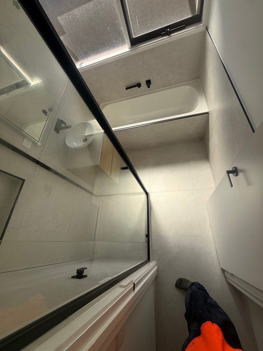 Completed bathroom renovation — new bath with large-format stone tiles