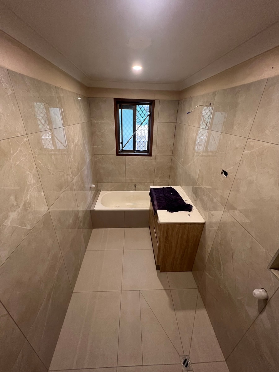 Completed bathroom renovation — beige tile and bathtub